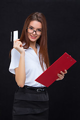 Image showing The young business woman with credit card and tablet for notes on gray background