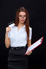 Image showing The young business woman with credit card and tablet for notes on gray background