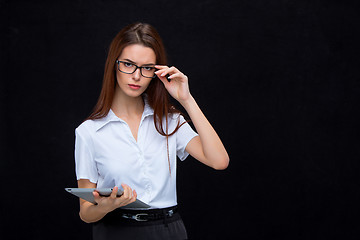 Image showing The young business woman with tablet on black background