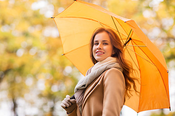 Image showing happy woman with umbrella walking in autumn park