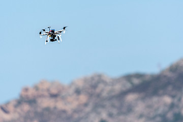 Image showing Drone with camera hovering over mountains