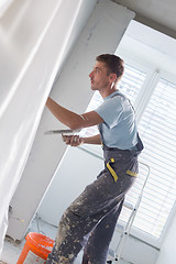 Image showing Plasterer renovating indoor walls and ceilings.
