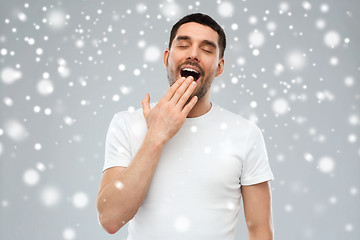 Image showing yawning man over snow background