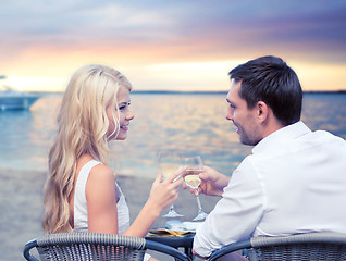 Image showing couple drinking wine in cafe on beach