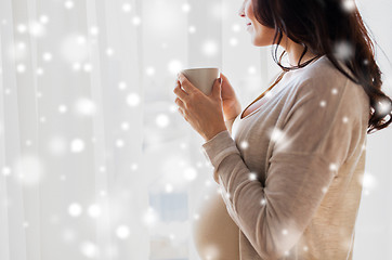 Image showing close up of pregnant woman with tea cup at window