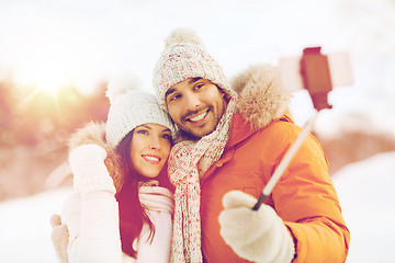 Image showing happy couple taking selfie by smartphone in winter