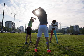 Image showing multiethnic group of people stretching in city park