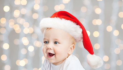 Image showing baby boy in christmas santa hat over blue lights