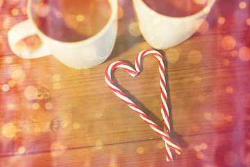 Image showing christmas candy canes and cups on wooden table