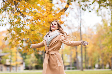 Image showing beautiful happy young woman walking in autumn park