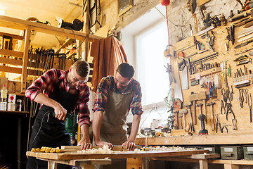 Image showing carpenters with drill drilling plank at workshop