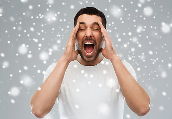 Image showing crazy shouting man in t-shirt over snow background