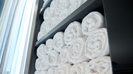 Image showing rolled white bath towels at hotel spa