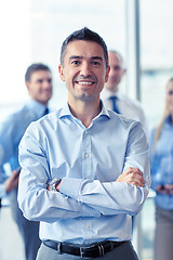 Image showing smiling businessman with colleagues in office