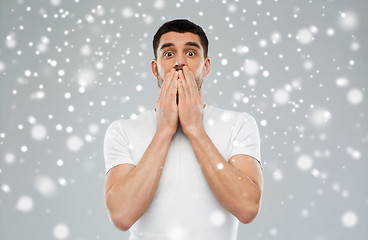 Image showing scared man in white t-shirt over snow background