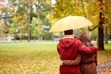 Image showing happy couple with umbrella walking in autumn park