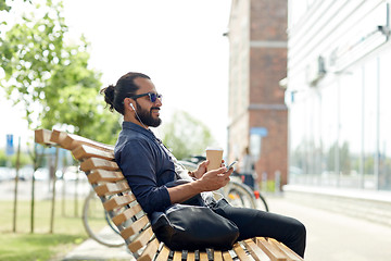 Image showing man with earphones and smartphone drinking coffee