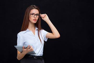 Image showing The young business woman with tablet on black background