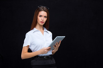 Image showing The young business woman with tablet on black background