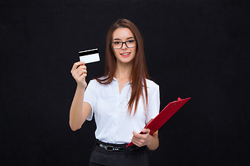 Image showing The young business woman with credit card and tablet for notes on gray background