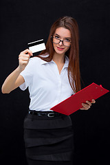 Image showing The young business woman with credit card and tablet for notes on gray background