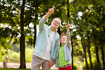 Image showing grandfather and boy pointing up at summer park