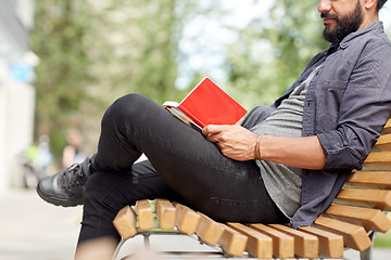 Image showing close up of man writing to notebook on city street