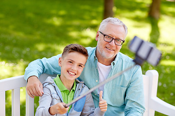 Image showing old man and boy taking selfie by smartphone