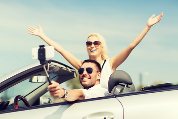 Image showing happy couple in car taking selfie with smartphone