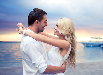 Image showing happy couple hugging over sunset beach background