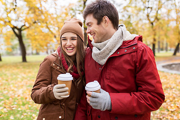 Image showing happy couple with coffee walking in autumn park