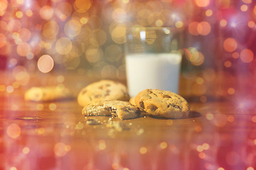 Image showing close up of cookies and milk over christmas lights