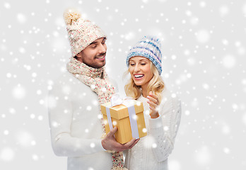 Image showing smiling couple in winter clothes with gift box