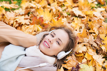 Image showing woman with headphones listening to music in autumn