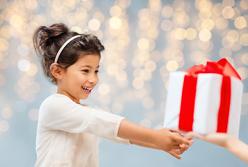 Image showing smiling little girl giving or receiving present