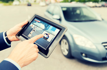 Image showing close up of hands with news on tablet pc and car