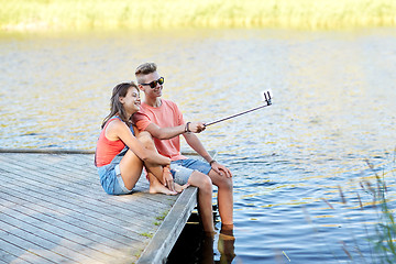 Image showing happy teenage couple taking selfie on smartphone