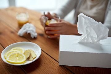 Image showing ill woman drinking tea with lemon and ginger