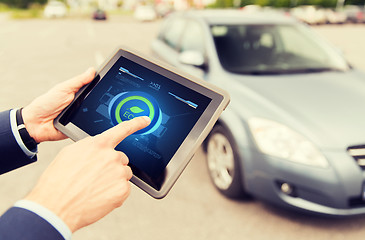 Image showing close up of male hands with tablet pc and car