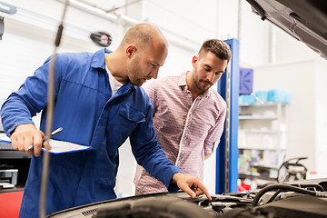 Image showing auto mechanic with clipboard and man at car shop