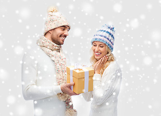 Image showing smiling couple in winter clothes with gift box