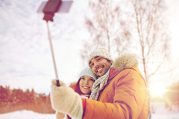 Image showing happy couple taking selfie by smartphone in winter