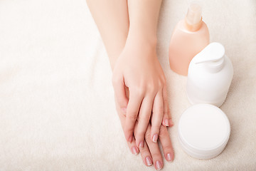 Image showing Woman\'s beautiful hands with care cream bottles