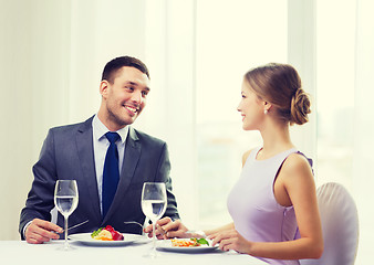 Image showing smiling couple eating main course at restaurant