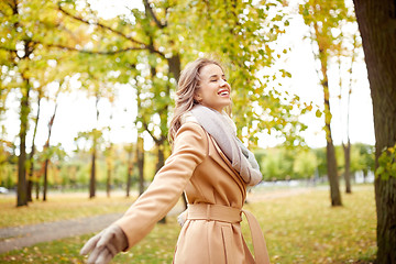 Image showing beautiful happy young woman walking in autumn park