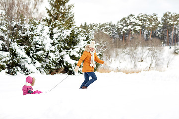 Image showing happy father pulling sled with child in winter