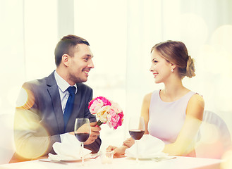 Image showing smiling man giving flower bouquet at restaurant