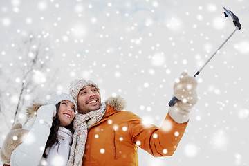 Image showing happy couple taking selfie by smartphone in winter