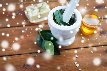 Image showing mortar and pestle with leaves on wood