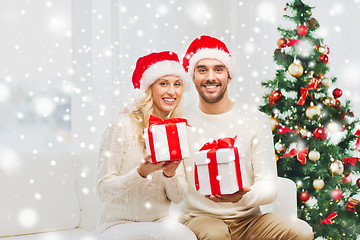 Image showing happy couple at home with christmas gift boxes